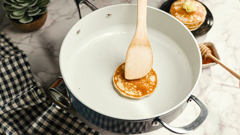 Wooden spatula being used on Cosmic Cookware's ceramic pan.