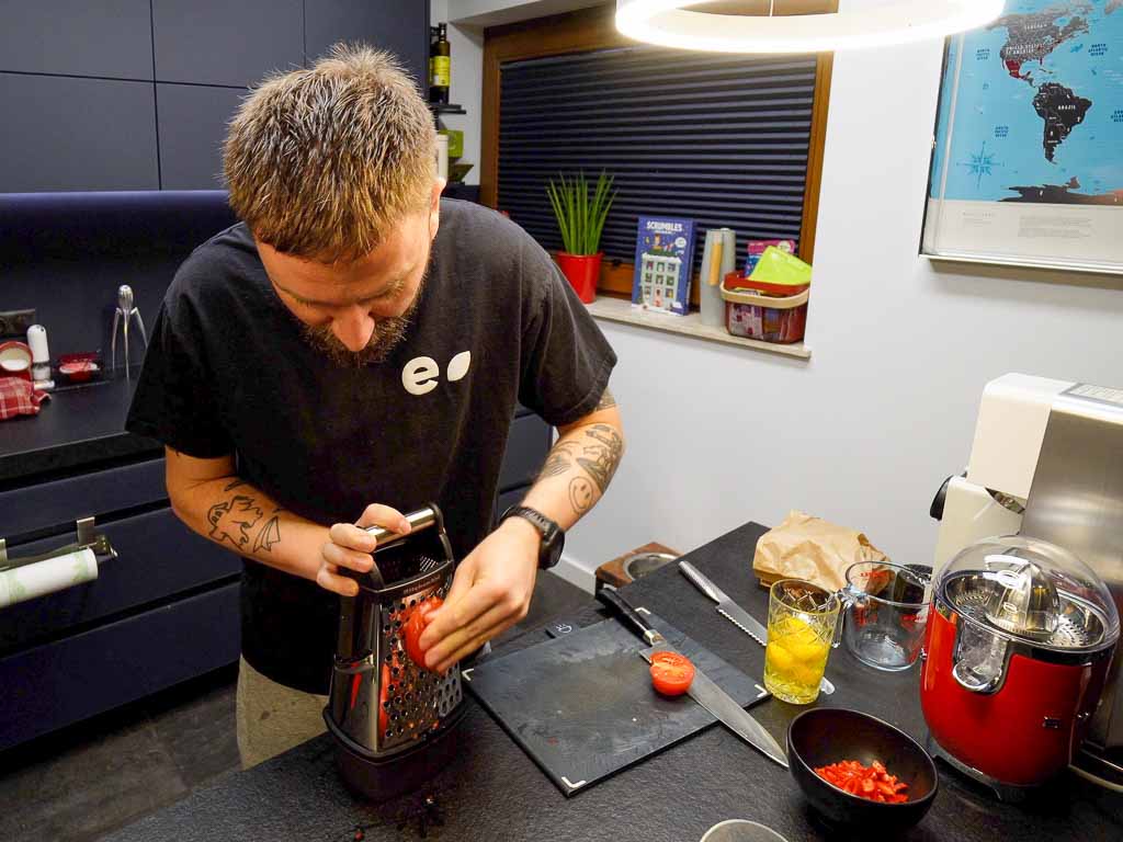 grating tomatoes on a grater