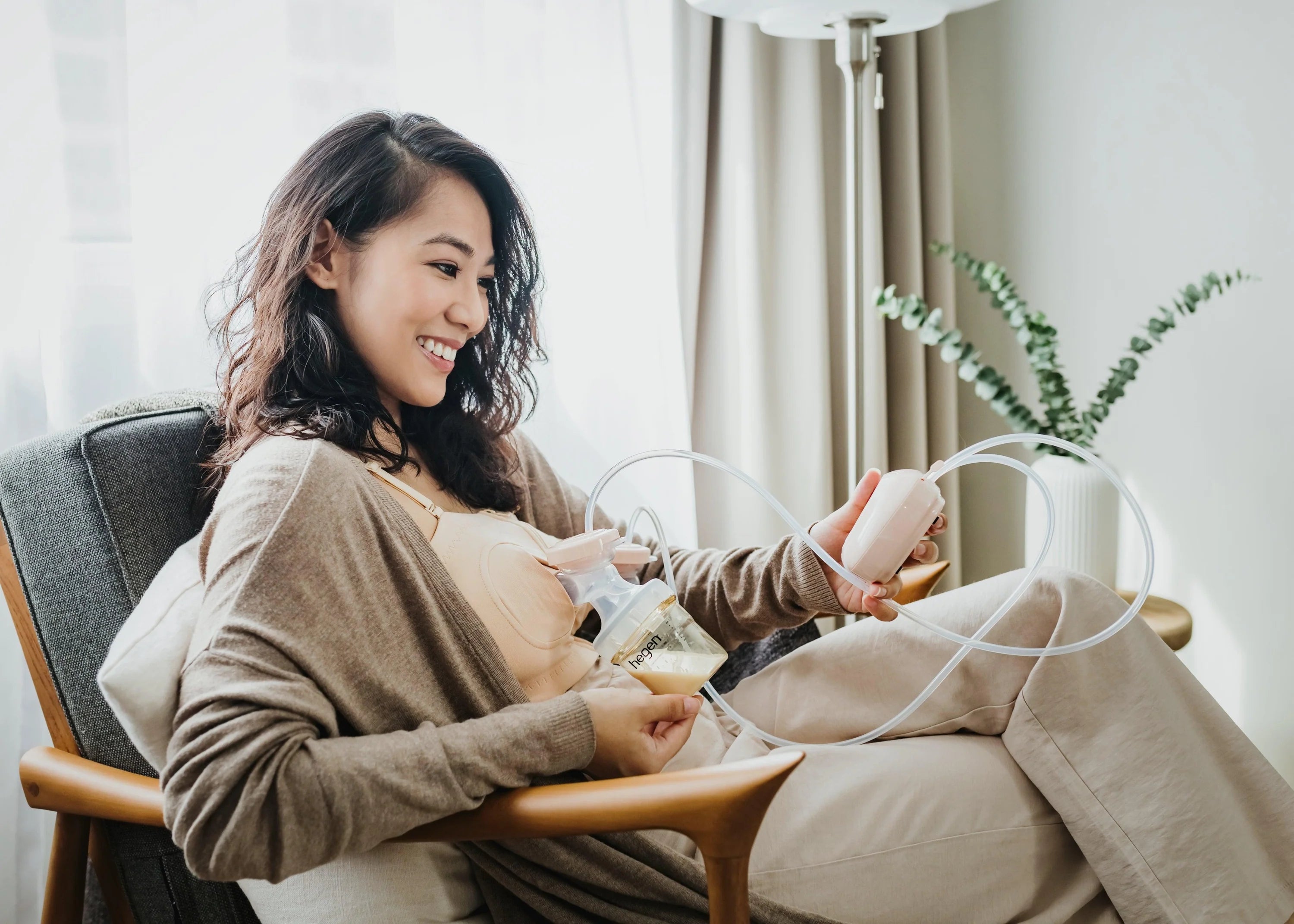 mother pumping breast milk with hegen electric breast pump