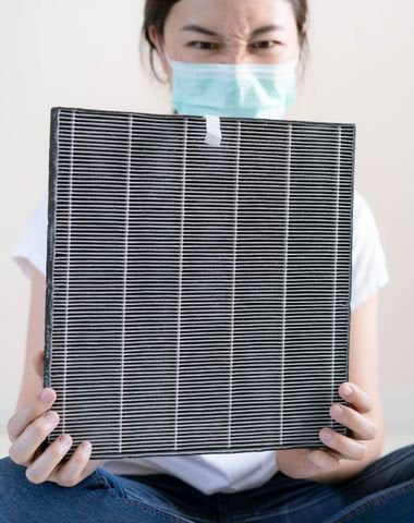 Image of a woman changing her furnace filter