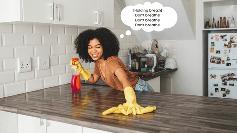 woman cleaning her countertops with a thought bubble reading "don't breathe!"
