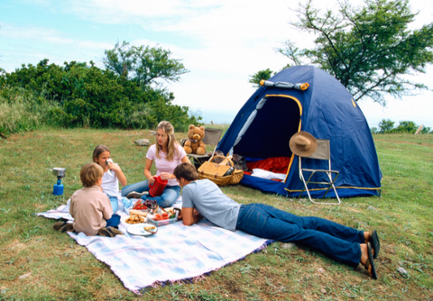 Family using a blanket while camping