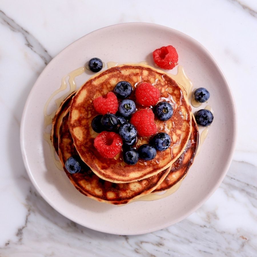 PBCo. Protein Pancake stack fresh berries and SF maple syrup on a plate.