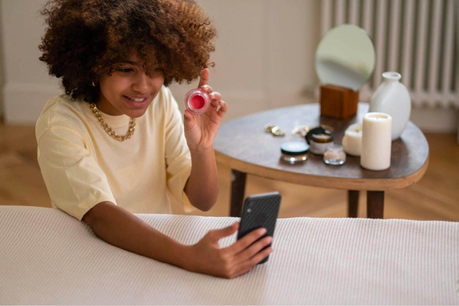 Influencer trzyma balsam do ust przed kamerą telefonu