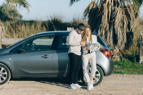 A man and a woman standing next to a car