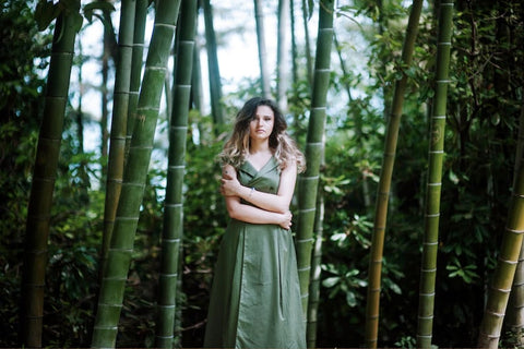 woman posing between bamboo trees