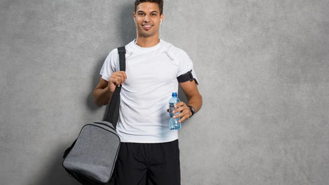 man carrying a bag and holding a bottle