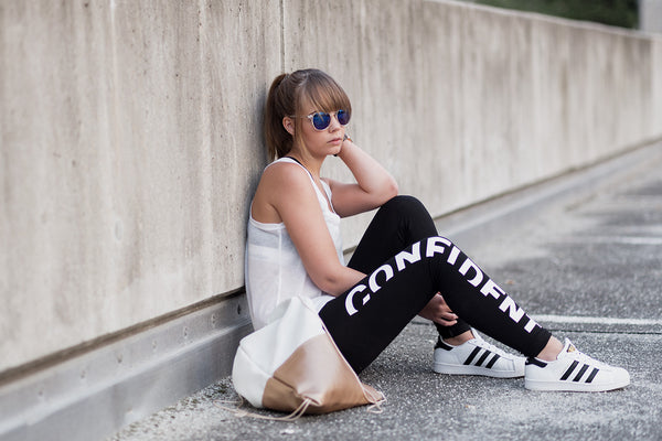 Woman sitting on a roadside wearing sportswear