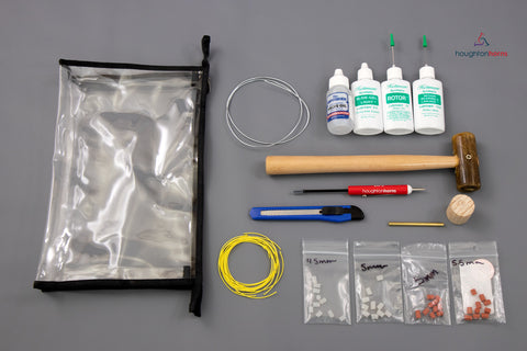 an acrylic bag with tools for repairing brass instruments