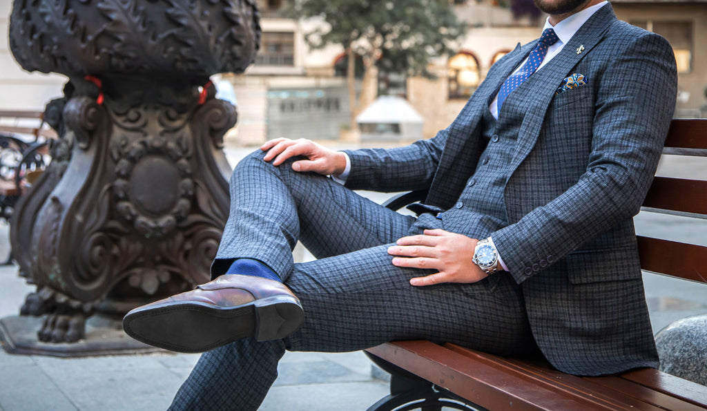 Man in a bespoke or tailored suit sitting on a park bench