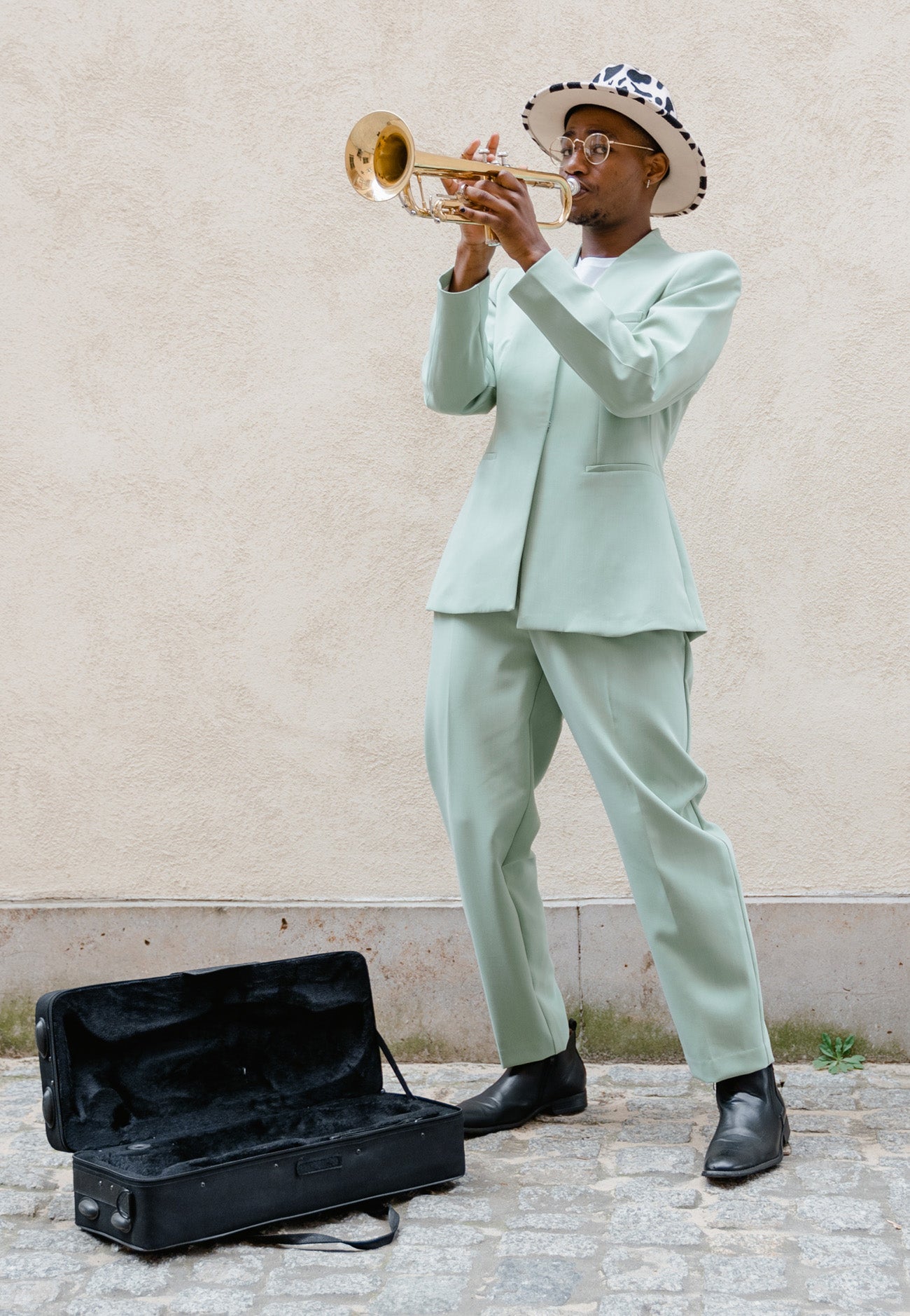Musician wearing light green suit with black shoes