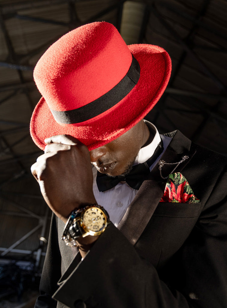 Man in red hat tipping his hat in respect