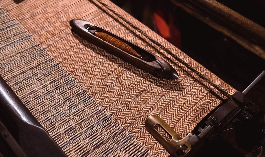 Tweed fabric being woven in herring pattern