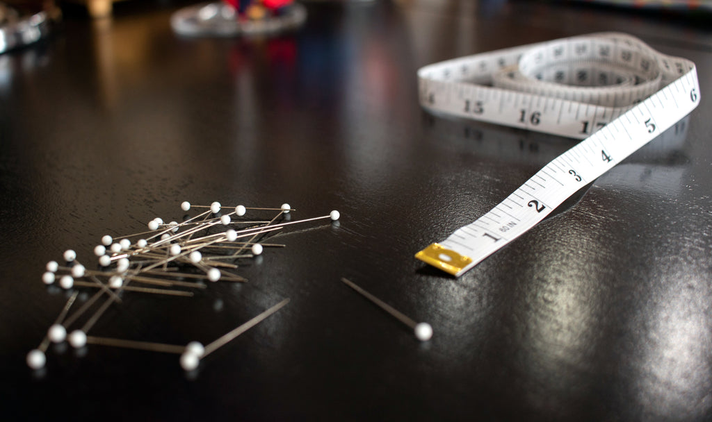 A tailor's suit alteration tools - the measuring tape and needles