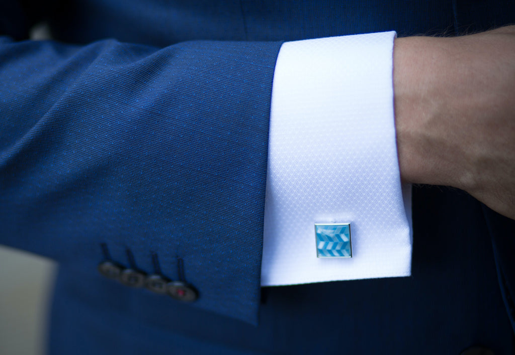Stylish cufflinks on a white shirt and navy suit
