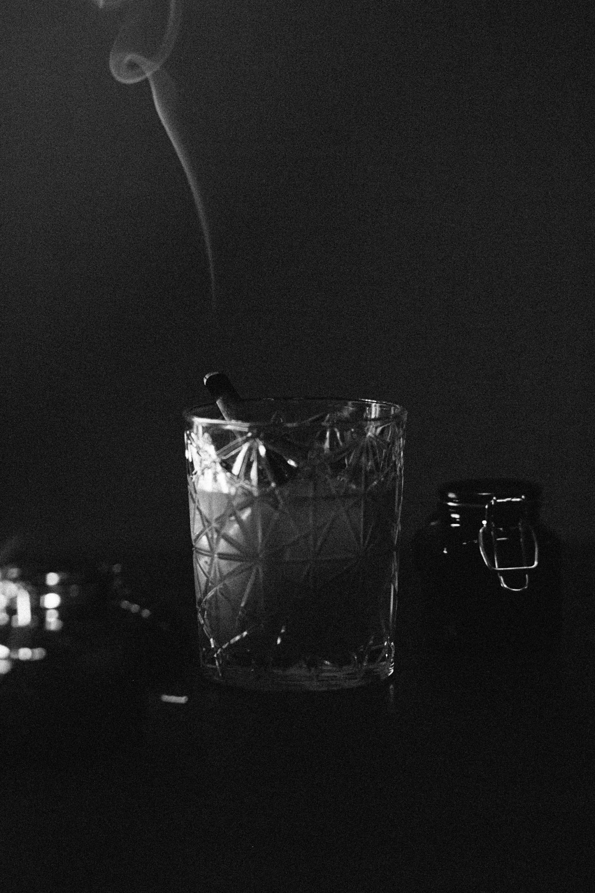 a glass of cocktail with a cigarette inside