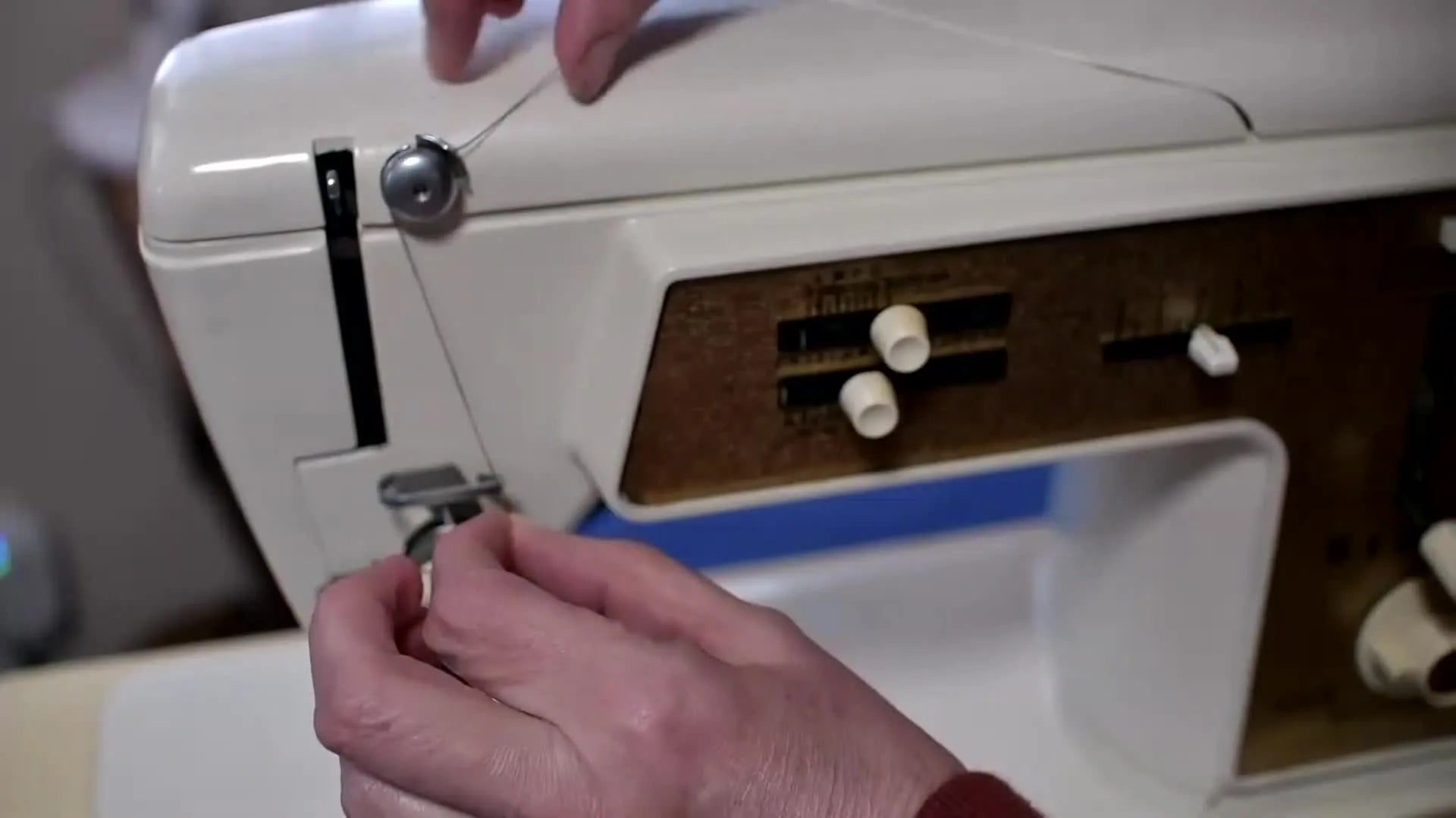 Thread going around the second circular guide down towards tension discs