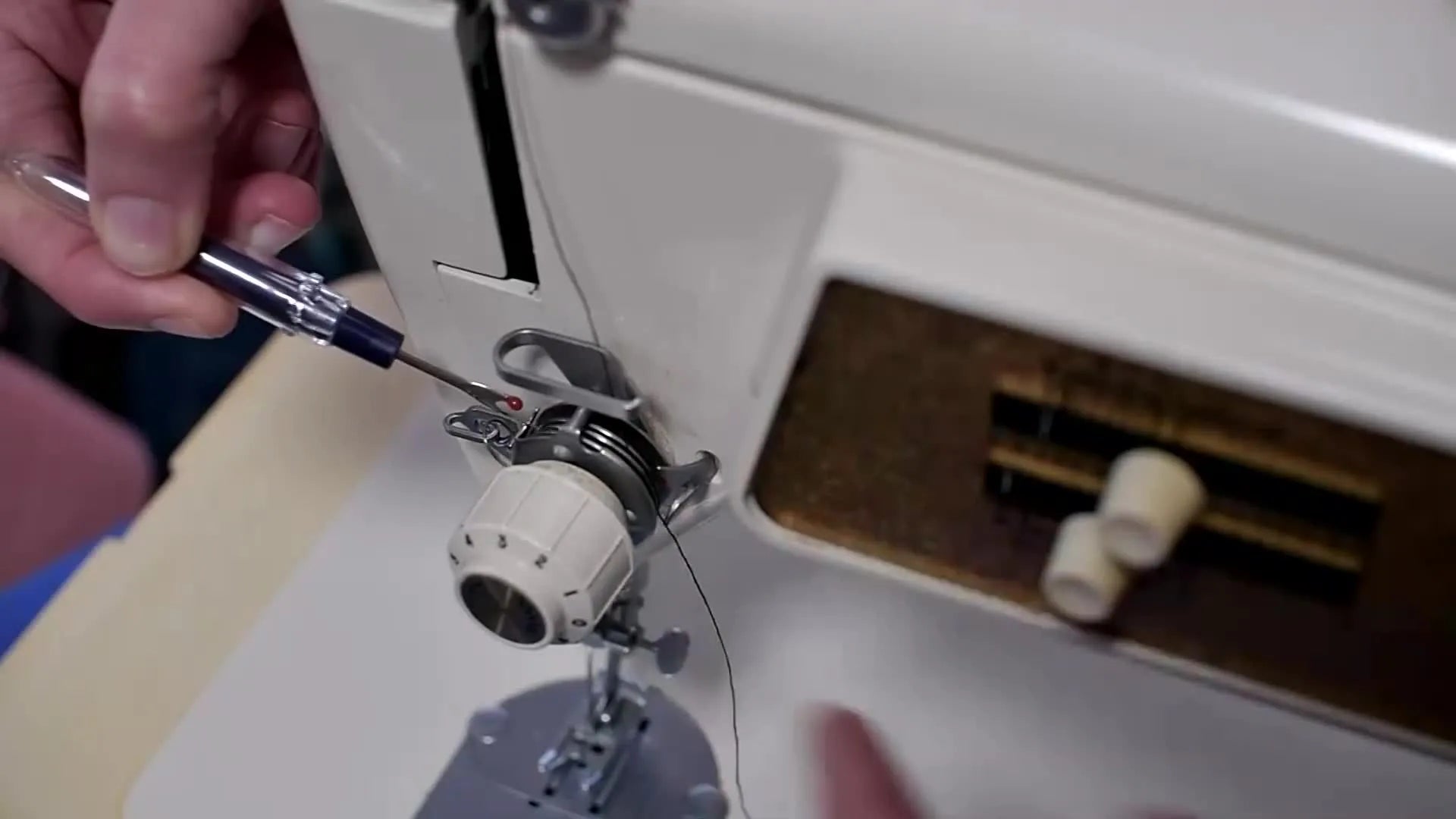Screwdriver pointing to the silver tension discs inside the assembly
