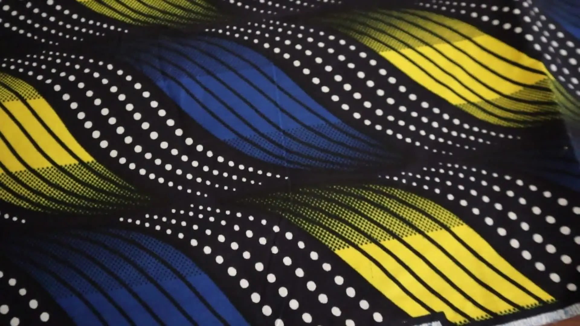 Blue, yellow, and black wavy African wax block print fabric.
