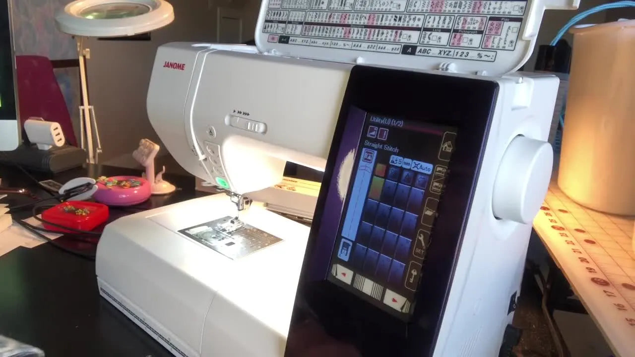 Hand inserting USB stick into Janome machine port