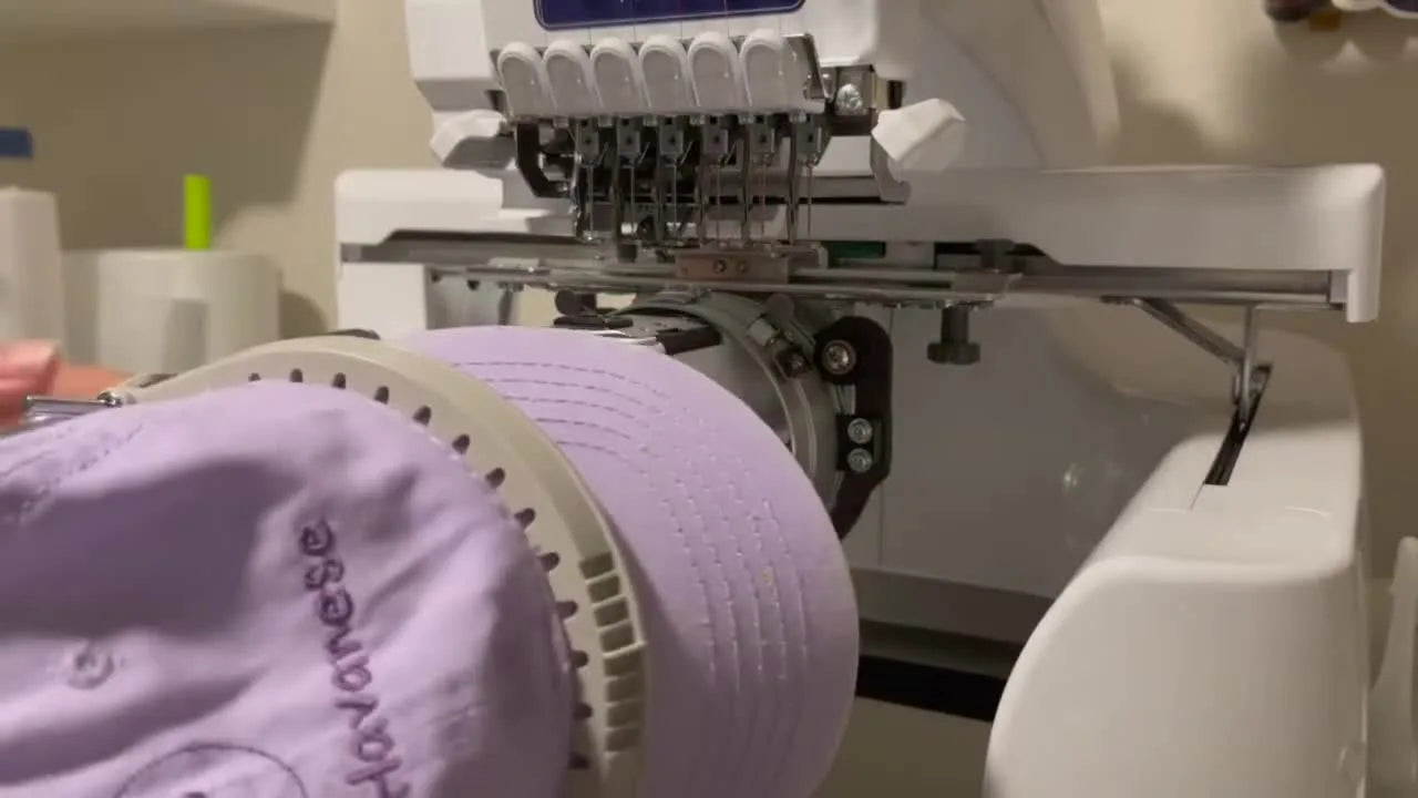 Woman attaching the small, black cap retaining piece to the front of the cap driver.