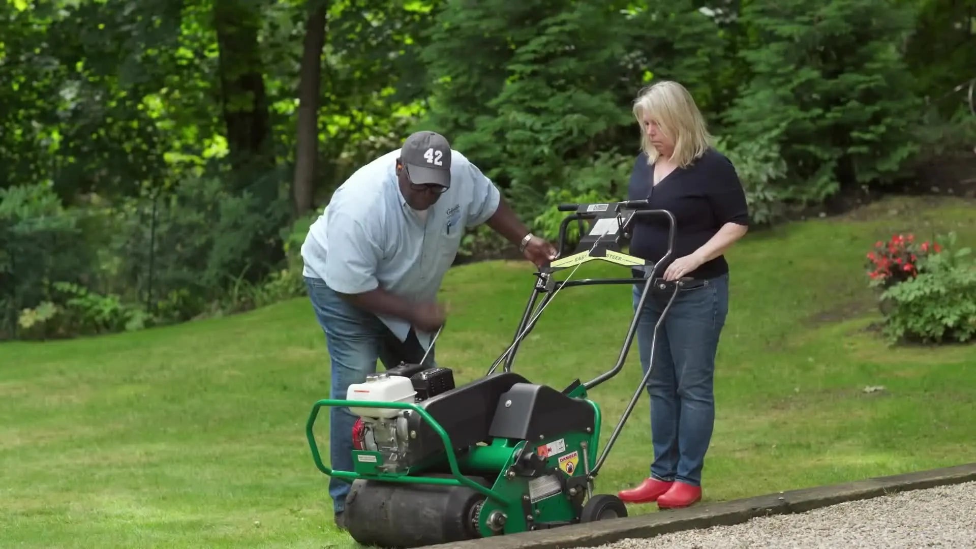 Valerie operating the core aerator with Lee instructing her.