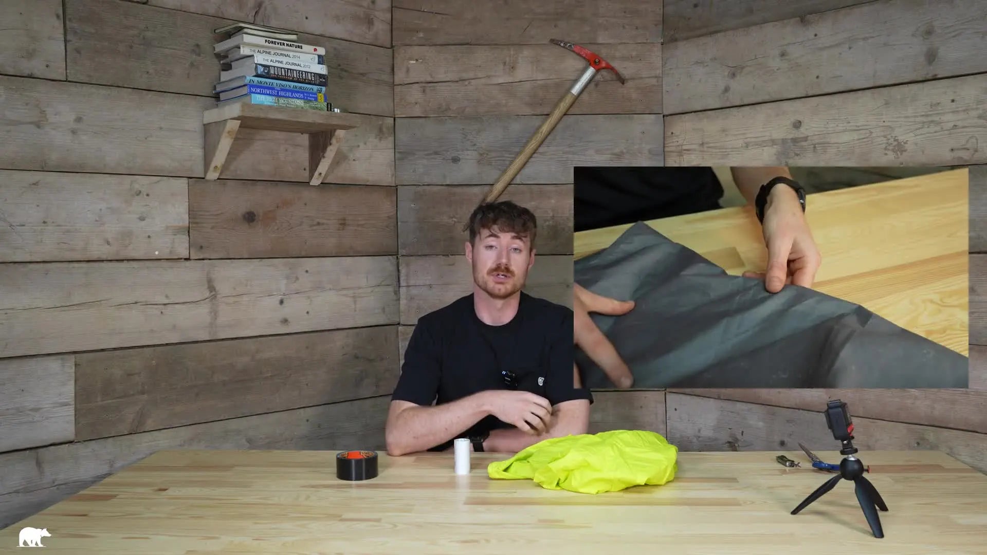 Hands cleaning a grey tent footprint with a cloth.
