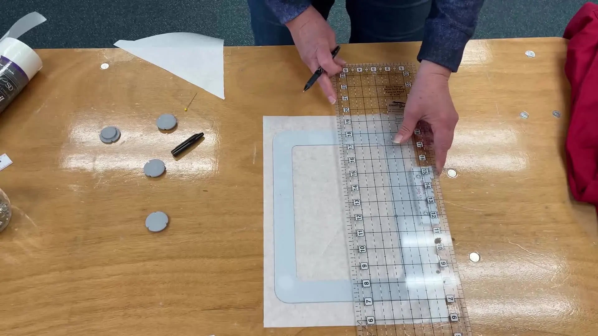 Marking an 'X' on the stabilizer with a ruler and pen.
