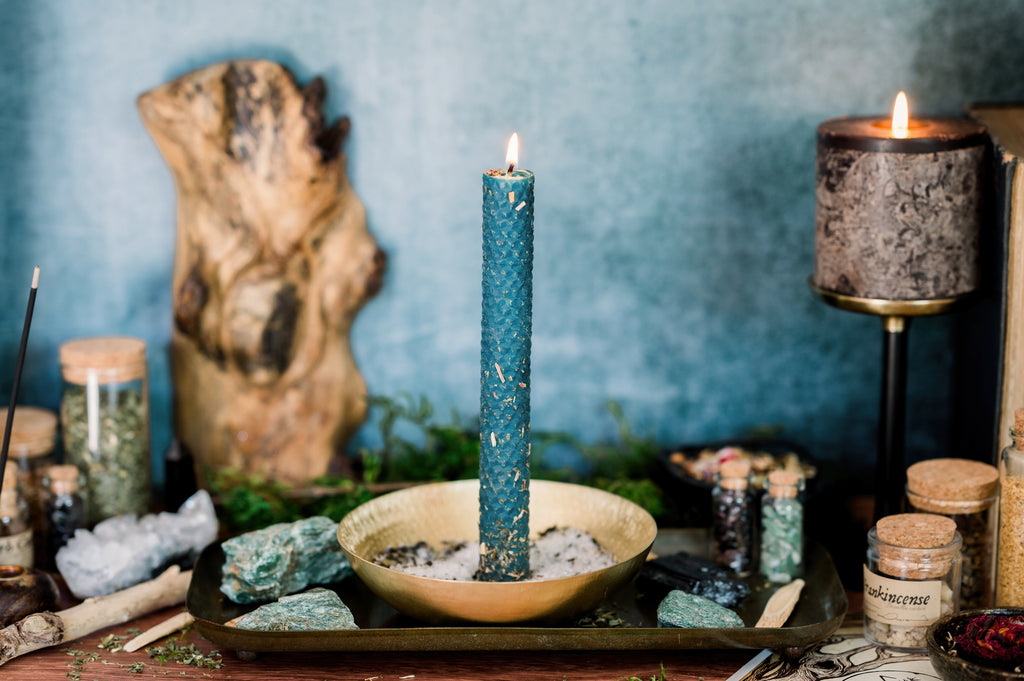 blue beeswax spell candle burning on altar