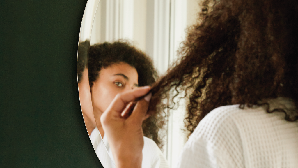 Woman looking at the ends of her hair