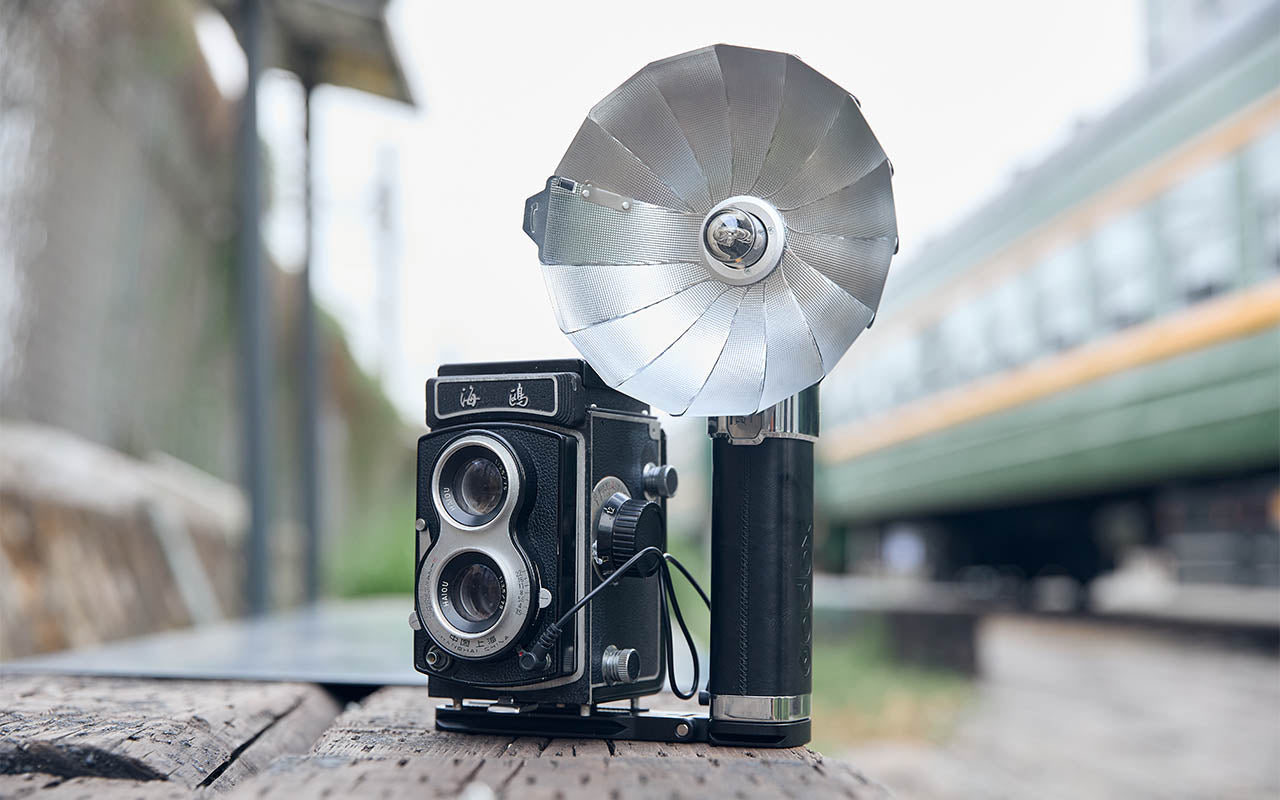 godox Lux Master Retro Flash mounted to an old Twin Lens Reflex Camera placed on a Table