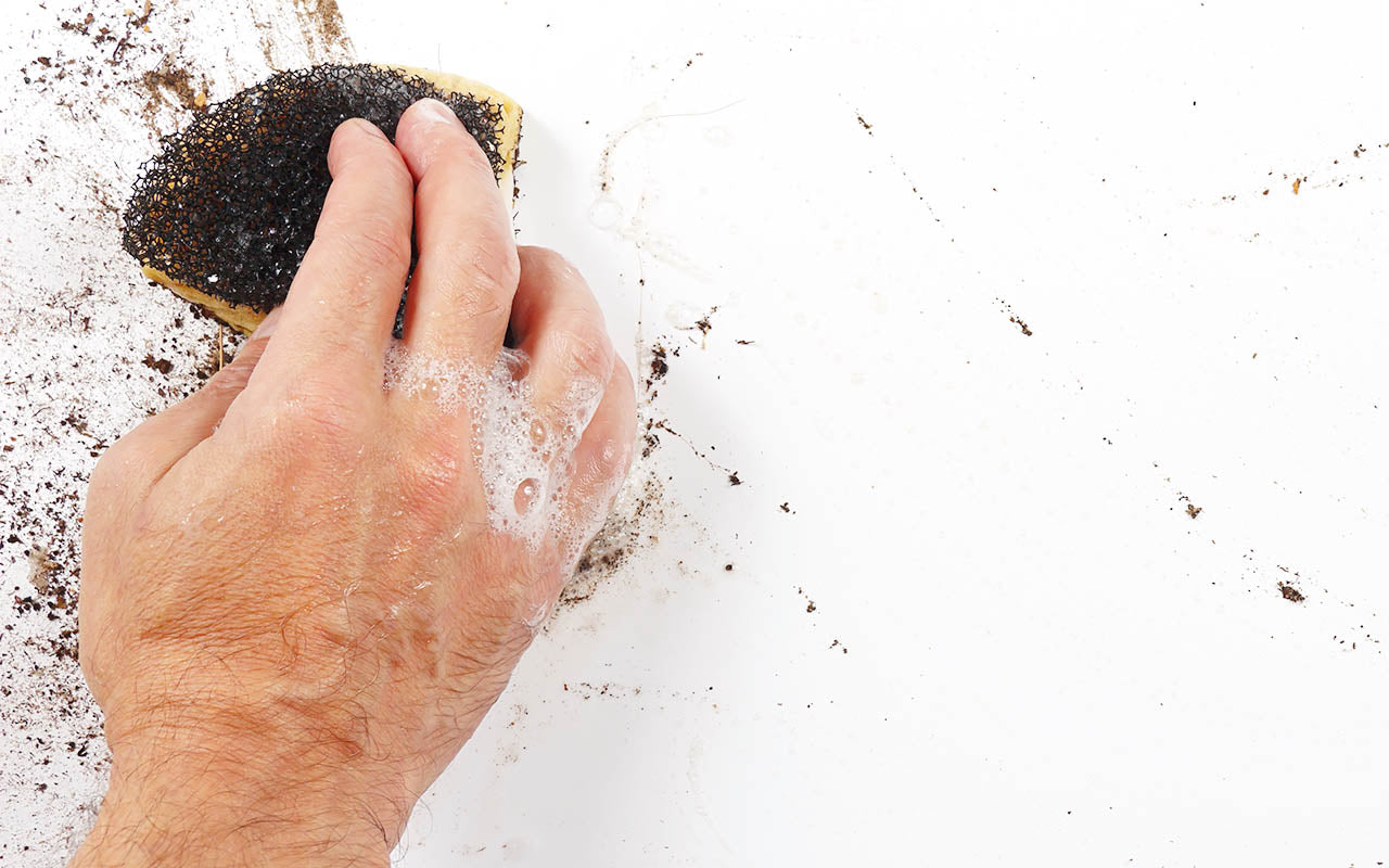 PVC Backdrop being wiped clean with a sponge and soapy water