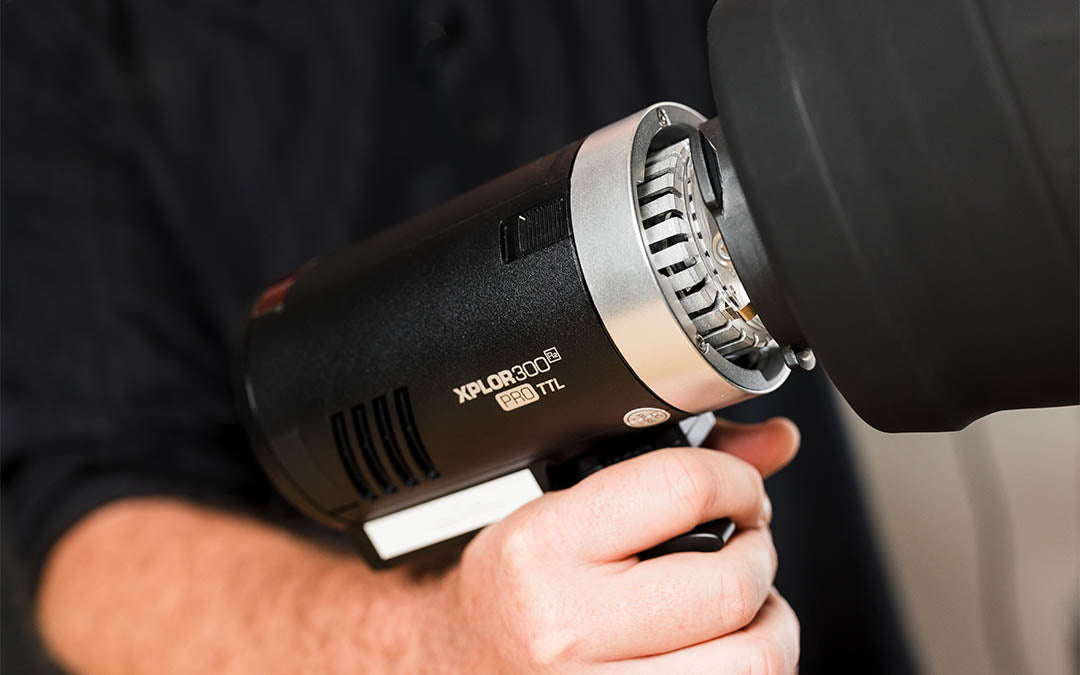 Man attaching MagMod XL reflector to a Godox AD300Pro/Flashpoint XPLOR 300Pro