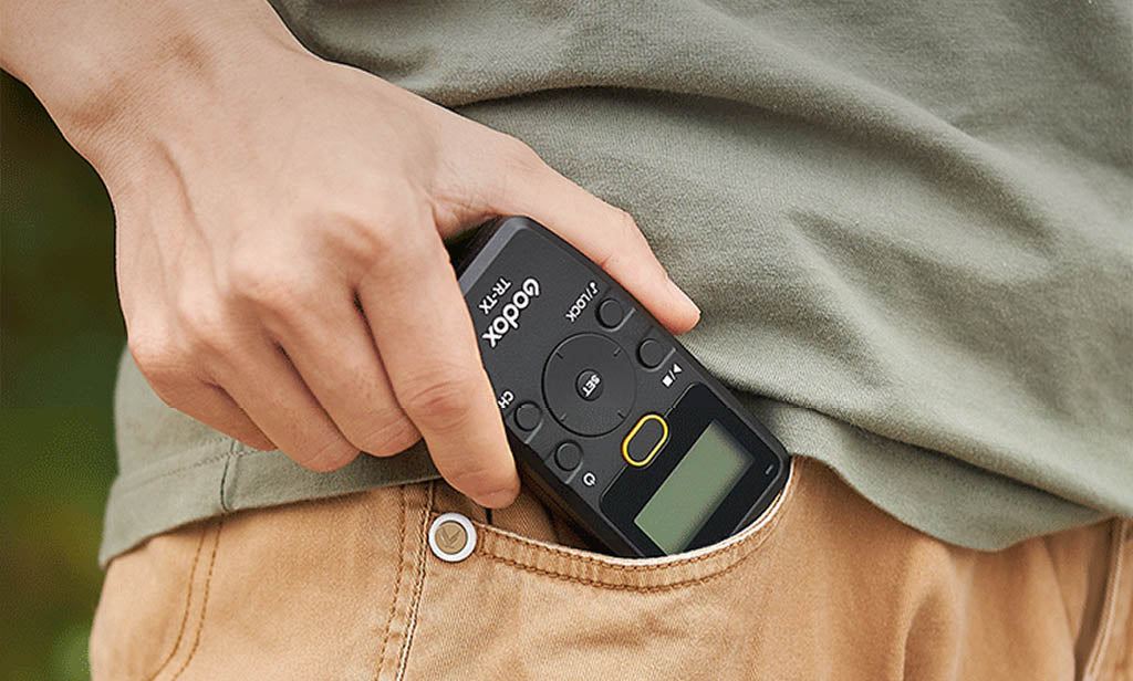 Godox TR-TX Transmitter being placed into a person's pocket