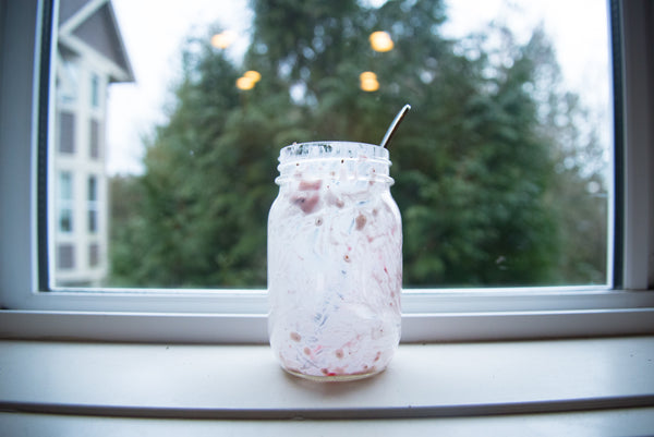 an empty breakfast chia pudding mason jar sitting on a window sill