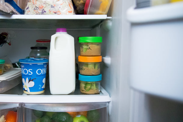 reusable intelligent lids on mason jars in a fridge next to milk and greek yogurt