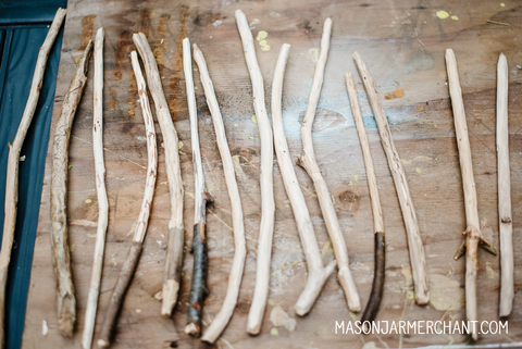 rough hand carved Harry Potter wands lined up on a sheet of plywood ready to be customized at a Harry Potter themed birthday party