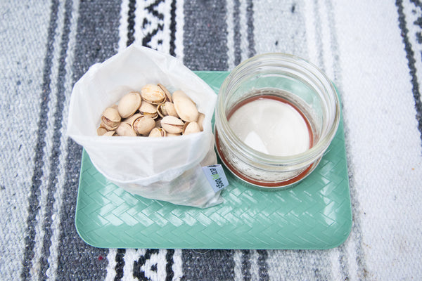 reusable bulk bag full of pistachios and empty mason jar