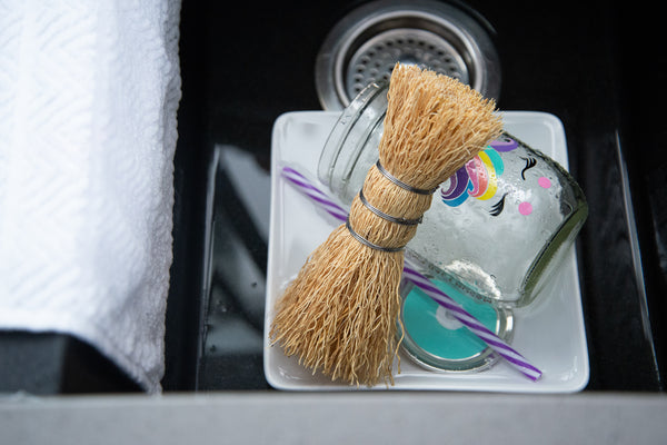 straw dish scrubber in a sink full of dirty dishes