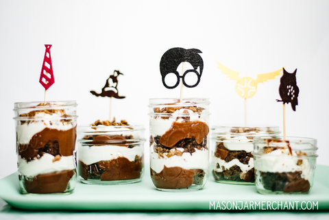 layered chocolate and whipped cream trifle in individually sized mason jars topped with felt Harry Potter cupcake toppers