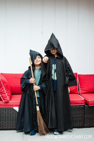 two boys wearing black wizard clocks made from thrifted flat sheets