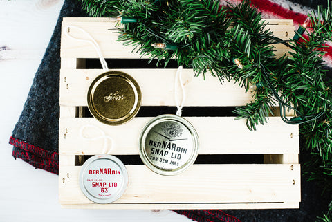 three vintage flat lid mason jar ornaments on a wooden crate