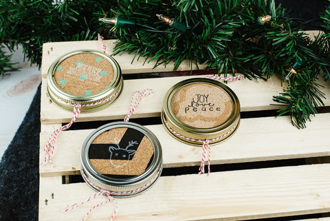 set of three handmade mason jar ornaments made from cork and stamped with holiday sayings and images