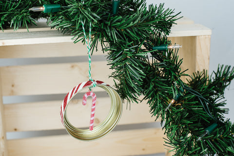 handmade mason jar ring ornament with red and white striped miniature candy cane and red and white glittery edge