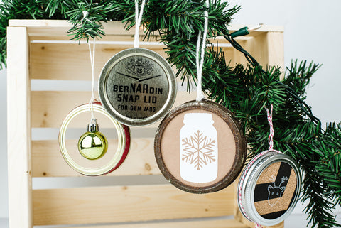 four ornaments handmade from used mason jar flat lids and rings and Christmas craft items