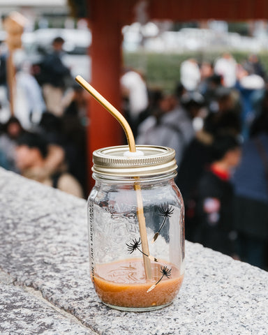 mason jar tumbler with gold straw and half full of coffee