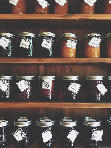 Jam jars sitting on a wooden shelf