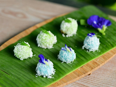 A plate of blue pea ondeh ondeh, plated with farm-to-table blue pea flowers.