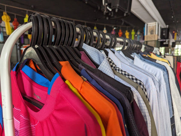 Clothes rack at a thrift shop showing formal shirts in various colours.