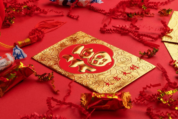 A gold and red hong bao (red packet) that is traditionally given out in Chinese families during the Lunar New Year. The hong bao is embossed with a gold 'fú' character, which represents wealth.